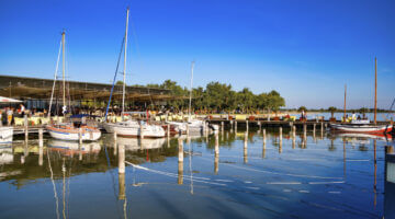 Malerischer Hafen an einem sonnigen Sommertag mit mehreren festgemachten Segelbooten, deren Masten u