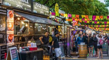 Lebhaftes Food-Truck-Festival in Argentinien mit bunten Wimpelketten, mehreren Streetfood-Ständen un