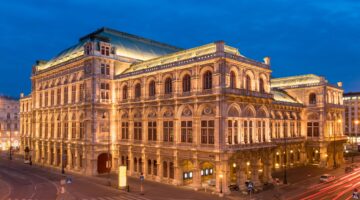 Die Wiener Staatsoper bei Nacht, prachtvoll beleuchtet im historischen Ringstraßenstil mit warmen Li