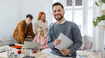 Junge Unternehmerin mit Kolleg:innen im Büro