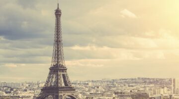 Panoramablick auf Paris mit dem Eiffelturm im Vordergrund und der weitläufigen Stadtsilhouette im Hi